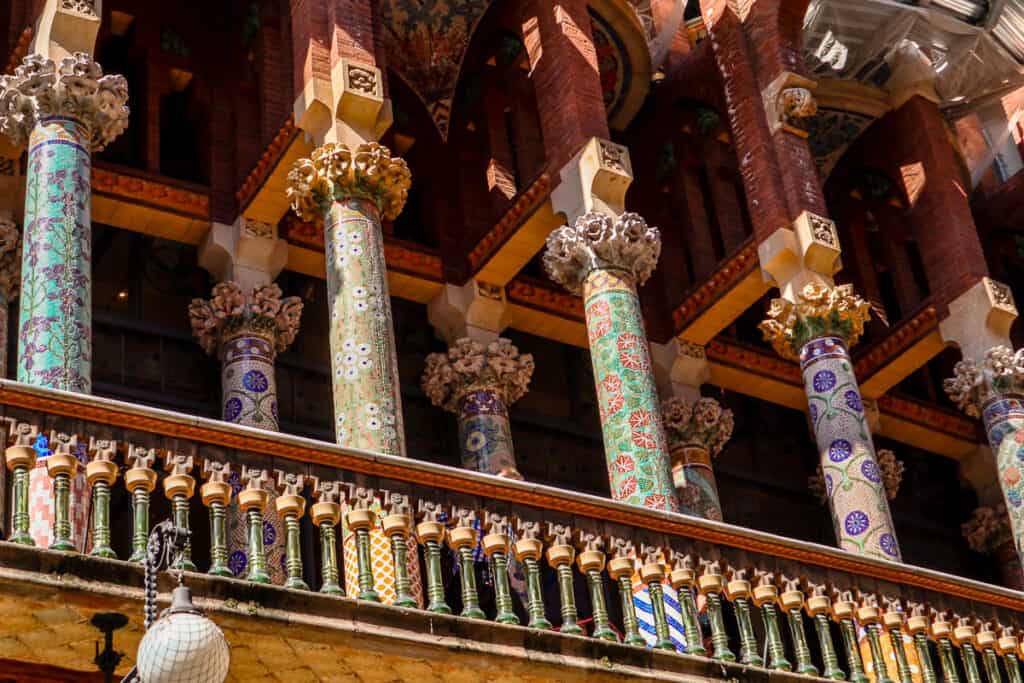 Decorative tiled columns and ornate architecture of the Palau de la Música Catalana's balcony, a stunning example of Barcelona's rich architectural heritage.
