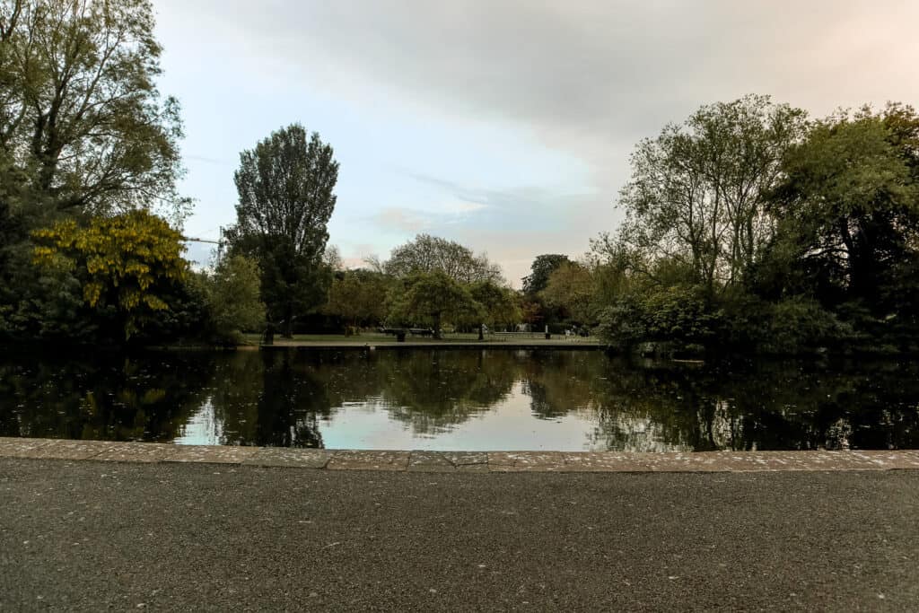 Tranquil scenery of St. Stephen's Green Park in Dublin, with lush green trees reflecting on a calm lake